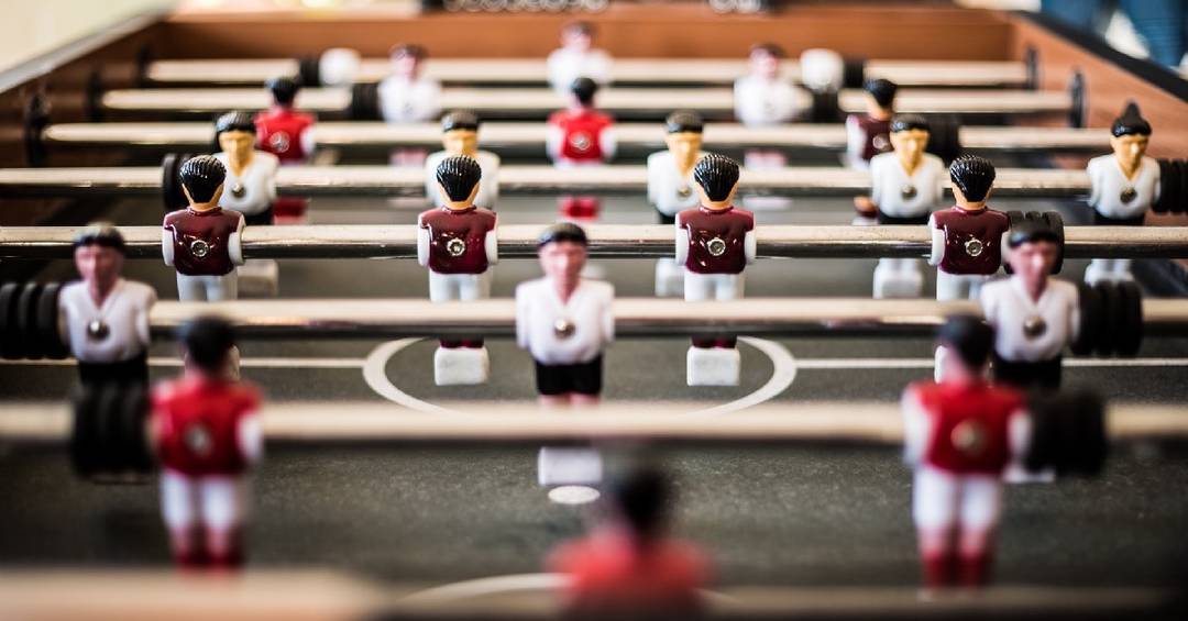 Nahaufnahme auf ein Tischfußball-Spiel mit den einzelnen Spielfiguren