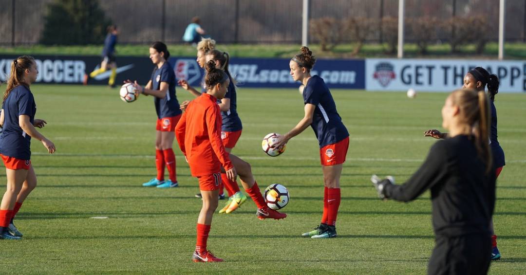 Einige Fußballspielerinnen auf einem Fußballplatz machen Fußball-Aufwärmübungen