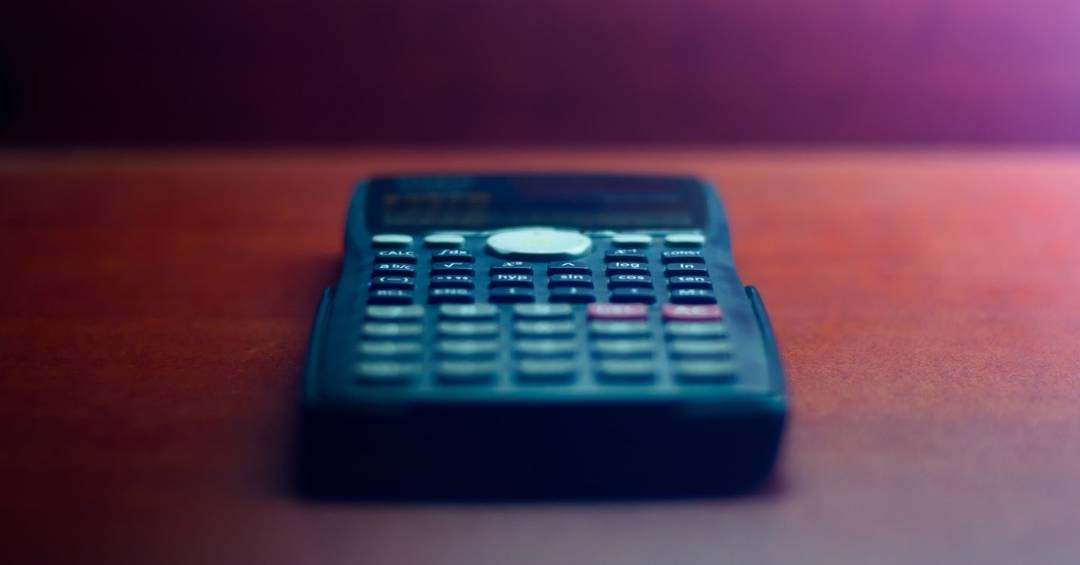 Nahaufnahme eines Taschenrechners, der auf einem Holztisch liegt