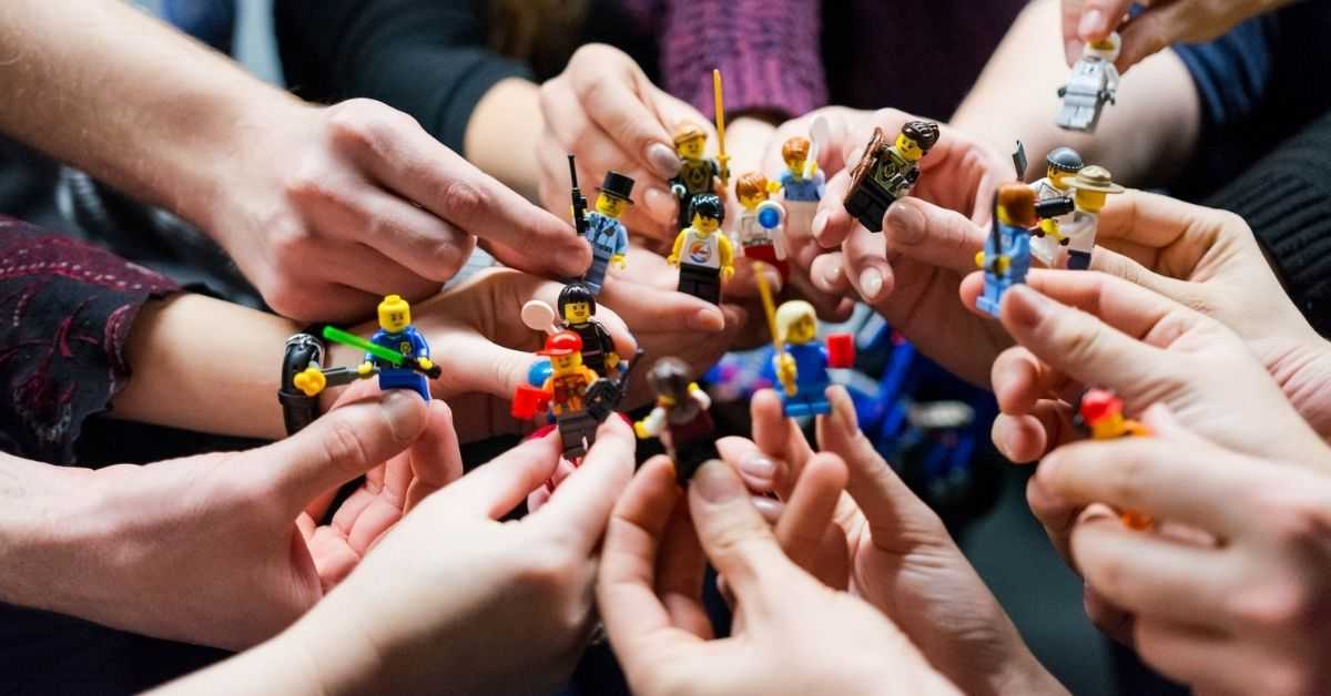 Vereinsmitglieder halten Lego-Figuren in den Händen, um verschiedene Facetten des Vereinslebens zu zeigen